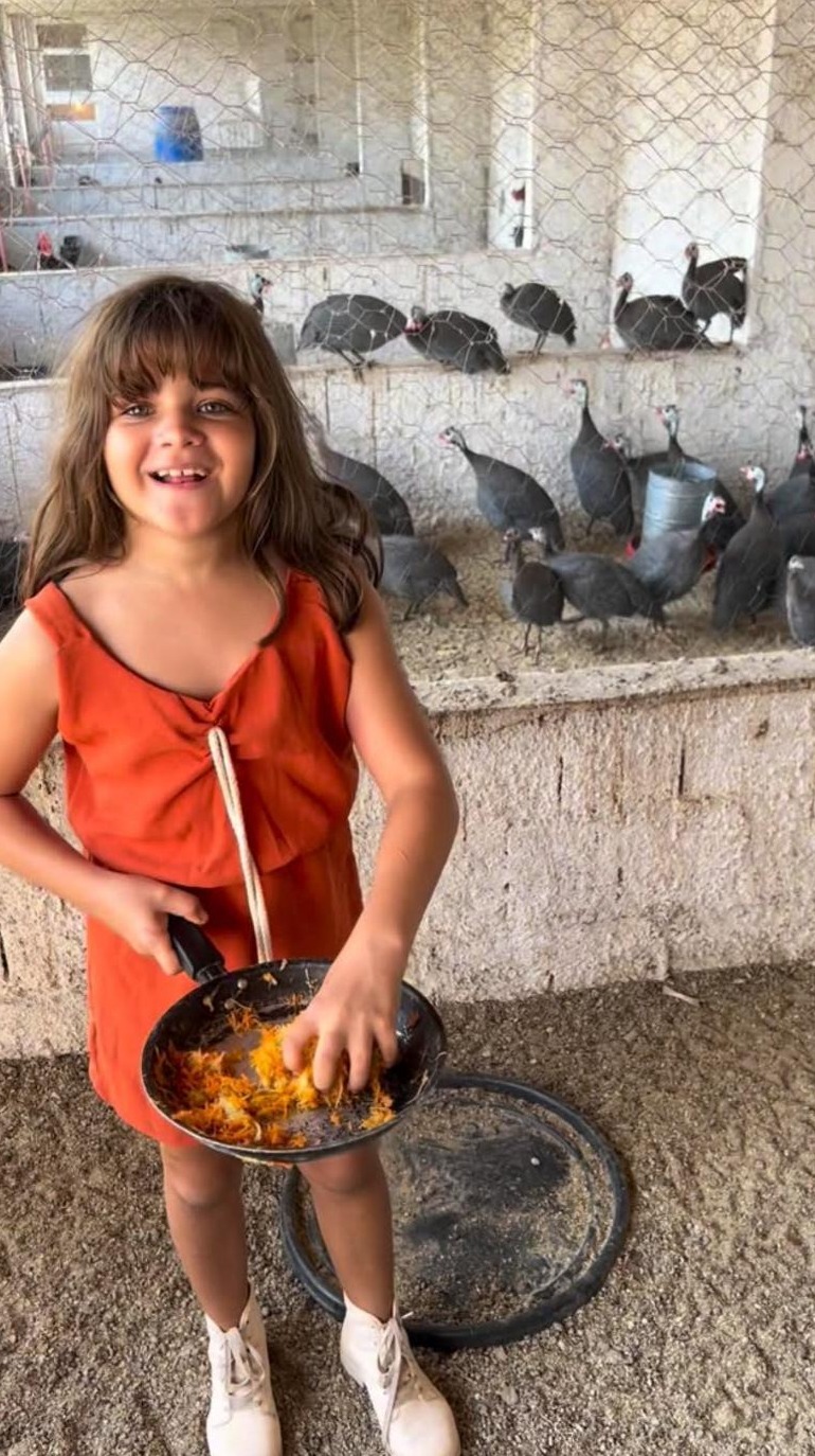 Criança interagindo com galinhas no quintal
